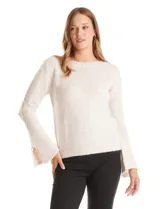 Buzo de tejido melange color beige, con cuello redondo y mangas largas con terminación acampanada. Presenta apliques de perlas decorativas a lo largo del escote y las mangas.