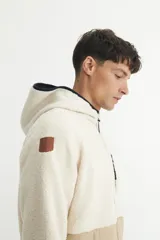 Campera con capucha en sherpa doble faz combinada con nylon de alta calidad. Detalle capitoneado con bolsillos en laterales. Bolsillo en pecho. Cierres engomados.