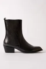 Bota de cuero negro estilo texano, con caña media, elástico lateral con costuras verticales y taco cuadrado.