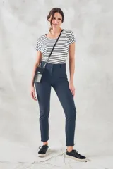 Pantalón de vestir azul marino, de corte skinny y tiro medio, con bolsillos laterales y cierre invisible en el lateral.