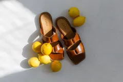 Sandalias de cuero color camel, con punta cuadrada y dos tiras anchas con detalle de nudo.