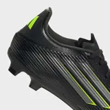 Championes de fútbol Adidas F50 League, color negro con detalles en amarillo neón y plateado. Presentan un exterior Fiberskin con estampado Sprintgrid y suela Sprintplate para terreno firme/multiterreno.