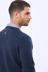 Buzo de lana azul con cuello redondo, manga larga y diseño tejido de punto.