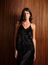 Top de lentejuelas negras con escote en V, tirantes finos y detalle de puntilla en el bajo.