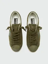 Zapatillas Golden Goose modelo Super Star, color verde oliva con efecto desgastado. Presentan una estrella lateral en tono más oscuro, cordones al tono y suela con acabado envejecido.