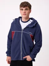 Campera de polar con cierre frontal, capucha ajustable y diseño con bloques de color azul marino y detalles en bordó. Presenta el logo de la marca bordado en el pecho.