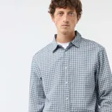 Camisa de manga larga con diseño de cuadros en tonos azules y blancos, cuello camisero y cierre frontal de botones.