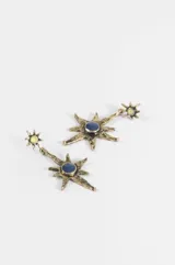 Caravanas colgantes con diseño de estrella de ocho puntas en metal envejecido, con un centro circular azul y un pequeño detalle superior con piedra amarilla.