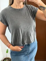 Remera corta de corte holgado, color gris con efecto lavado acid wash, cuello redondo y mangas cortas.
