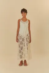 Vestido largo de tela artesanal color blanco con diseño de palmeras, de corte holgado, tirantes finos y escote redondo.