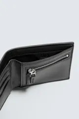 Billetera negra de cuero trenzado, con compartimento para billetes, tres compartimentos para tarjetas y un monedero con cierre mediante cremallera.