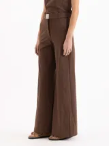 Pantalón wide leg color beige, de tiro medio-alto, con elástico en la espalda y tajos en las botamangas. Incluye cinto con hebilla del mismo tono y pinzas traseras.