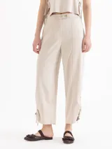 Pantalon de tiro medio color beige, confeccionado en twill, con fit relajado, pierna ancha estilo babucha, bolsillos laterales y traseros tipo ojal, y presillas en la cintura.