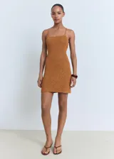 Vestido corto de tejido de punto con lúrex, color cobre, de corte entallado con escote cuadrado y tirantes finos. Presenta un diseño de espalda descubierta con cierre de lazo cruzado.