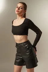 Top cropped negro de algodón, con escote redondo y mangas largas con aberturas para los pulgares.