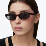 Lentes de sol con montura ovalada de diseño carey y lentes polarizadas en color negro.