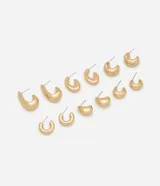 Kit de seis pares de aros tipo argolla de metal en acabado pulido dorado, con estructura tubular y diferentes tamaños y diseños orgánicos.