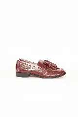 Mocasín de cuero color merlot con acabado brillante, detalle de flecos en el empeine y suela plana.