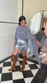 Vestido corto de dos piezas compuesto por una base strapless con frunces y acabado satinado, acompañada de una capa transparente desmontable de corte asimétrico.