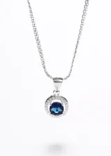 Collar de plata 925 con cadena tipo bismarck y dije circular estilo Lady Di, con una piedra central de zirconia azul rodeada por pequeñas zirconias blancas.