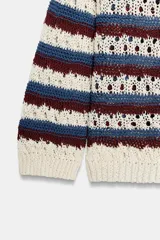 Chaqueta de punto calado con cuello redondo, manga larga y diseño a rayas horizontales en tonos blanco, azul y bordó. Cuenta con cierre frontal de botones y terminaciones en rib.