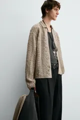 Sobrecamisa de hombre color beige, confeccionada en tejido de crochet con estructura abierta, cuello solapa, manga larga y cierre frontal de botones.