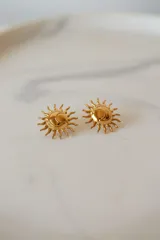 Caravanas doradas con diseño de sol con relieve y acabado brillante.