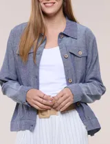 Camperita de lino liviana, marca Dash, con estampado botánico de hojas en tonos azules, verdes y tostados sobre base blanca. Presenta cierre frontal con botones, cuello clásico y bolsillos aplicados en el pecho.