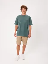 Remera negra de corte suelto y mangas cortas, con pequeño bordado a tono en el pecho.