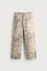 Pantalón baggy fit de algodón con diseño de cinco bolsillos, efecto lavado y estampado abstracto. Cuenta con cierre frontal de cremallera y botón.
