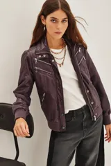 Campera estilo biker color ciruela, con múltiples cierres metálicos decorativos en el frente y mangas. Tiene cuello alto con broches, puños y cintura elastizados.
