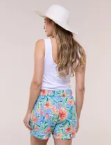 Short de calce relajado de rayón, con estampado floral en tonos celestes, naranjas y verdes. Cuenta con pretina lisa en el delantero y elástico posterior, bolsillos diagonales y pierna ancha.