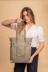 Cartera tipo shopper de gran capacidad en color beige, confeccionada en cuero sintético. Presenta un diseño funcional con asas dobles largas para llevar al hombro, un bolsillo frontal plano y compartimento principal con cierre. Incluye una correa ajustable y extraíble para utilizar como bandolera.