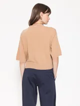 Sweater corto color beige, de mangas cortas y corte amplio.