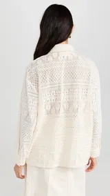 Camisa color blanco hueso con cuello clásico, tapeta con botones en la parte delantera y corte recto ligeramente oversize. Diseño con acabado de encaje.