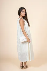 Vestido midi de corte amplio y silueta recta, con cuello redondo y diseño sin mangas. Confeccionado en tejido ligero de textura sutil, cuenta con bolsillos laterales.