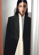 Blazer negro entallado de mezcla de lyocell y viscosa, con cuello pico, solapas de muesca, manga larga y dos bolsillos de parche laterales.