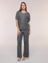 Blusa de calce relajado de lyocell en tono azul denim, con cuello a la base y cierre frontal de botones metálicos. Tiene mangas cortas abullonadas con puños elásticos.