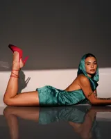 Minivestido satinado color verde esmeralda, con capucha, espalda descubierta y drapeado en la falda.