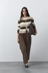 Cardigan de tejido suave con diseño de rayas horizontales en tonos marrones y beige, con cuello redondo y cierre frontal de botones.