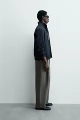 Cazadora azul marino de corte regular fit, confeccionada en tejido técnico repelente al agua. Presenta cuello subido, manga larga, bolsillos de vivo en cadera, bolsillo interior y acabados en rib en puños y bajo. Cierre frontal de cremallera oculta por solapa con botones a presión.