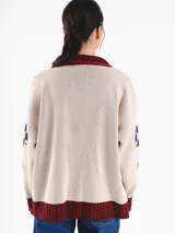 Campera tejida en jacquard con cierre frontal, cuello tipo polo y bolsillos delanteros. Diseño multicolor con estampado geométrico de rombos y detalles bordados a mano.