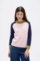 Sweater de punto con diseño color block, presenta cuerpo en color rosado, mangas en azul marino y detalles de cuello y puños en color verde oliva. Posee un corte holgado y cuello redondo a la base.