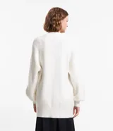 Cardigan abierto de punto pesado, color blanco, con mangas largas, bolsillos laterales y diseño alargado.