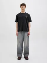 Remera negra de algodón con cuello redondo y manga corta. Estampado en la espalda con la frase "Almeria Art Exhb." y una imagen de un paisaje.