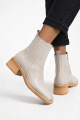 Bota corta de cuero color gris claro, con paneles laterales elásticos, puntera cuadrada y taco de madera de altura media.