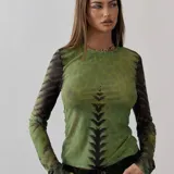 Top de microtul verde con estampado abstracto en tonos verdes y negros, de mangas largas y cuello redondo.