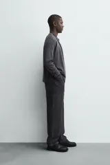 Cárdigan de punto con lana, de corte regular fit, cuello redondo y manga larga. Presenta cierre frontal con botones y acabados en rib en puños y bajo.