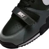 Championes Nike Air Trainer 1 de corte medio, con diseño en combinación de colores negro y gris. Presenta una correa ajustable sobre el empeine con el logo de la marca, el icónico swoosh lateral en color blanco y suela de goma con entresuela blanca.
