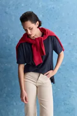 Remera negra de calce amplio, confeccionada en algodón liviano, con cuello redondo, mangas cortas y hombros levemente caídos.